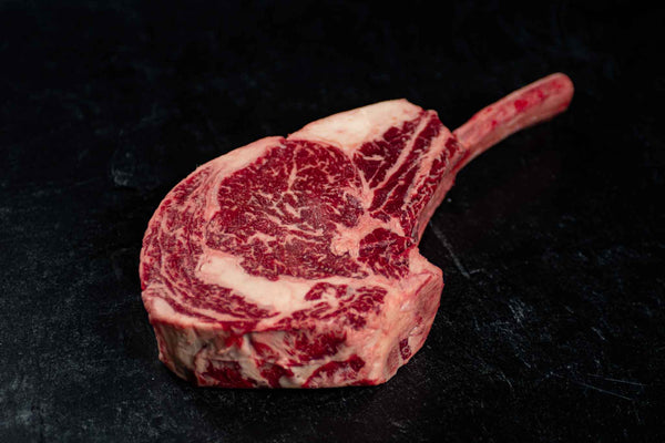 Certified ONYA® Tomahawk Ribeye photographed raw with beautiful marbling. Top-down view shows the three inch thick steak, as tender as Wagyu.