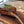 Large Certified ONYA® Tomahawk Ribeye 3 inches thick shown cooked on a wooden cutting board on a marble countertop. Rosemary can bee seen resting on top of the perfectly cooked steak