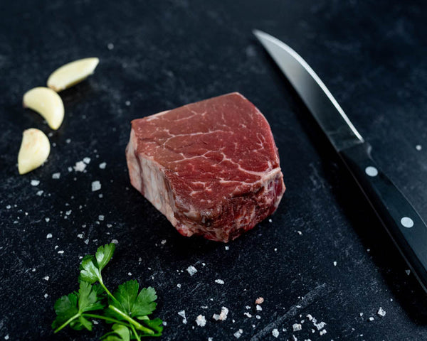 Side angle of a Certified ONYA® Filet mignon from BetterFed Beef company. Photographed beside a Wusthof gourmet steak knife 